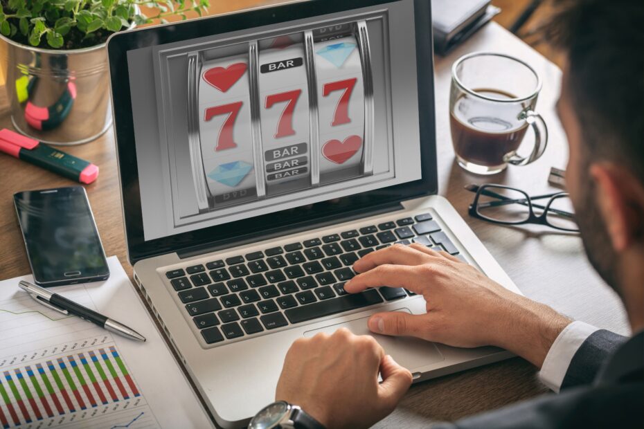 Ein Mann spielt an einem Laptop online Casino